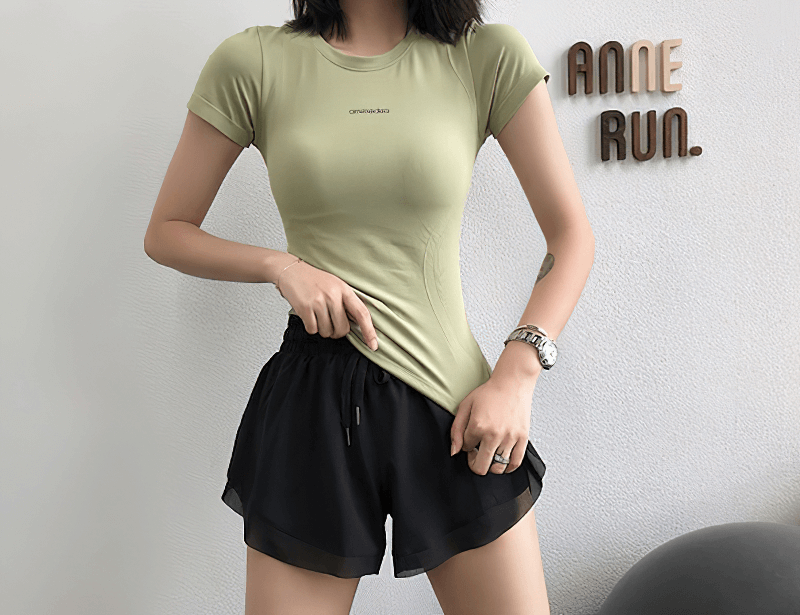 Woman wearing fitness female breathable short sleeve t-shirt and black sports shorts, perfect for running and workouts, anti-pilling fabric.